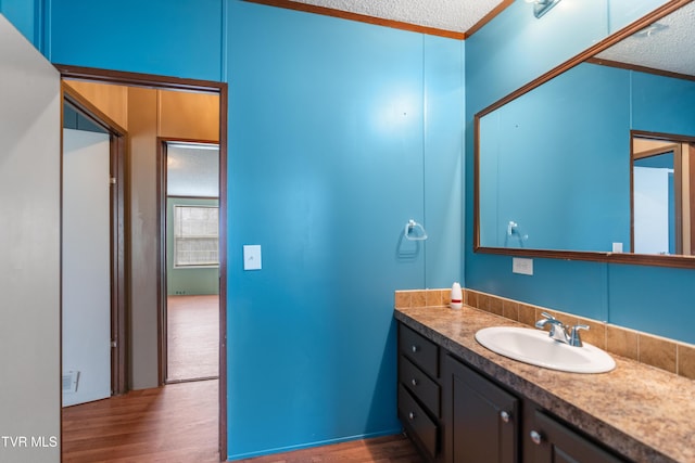 bathroom with vanity, visible vents, a textured ceiling, and wood finished floors