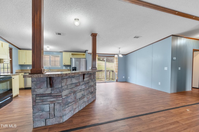 kitchen featuring cream cabinets, stainless steel appliances, visible vents, a wealth of natural light, and light wood finished floors