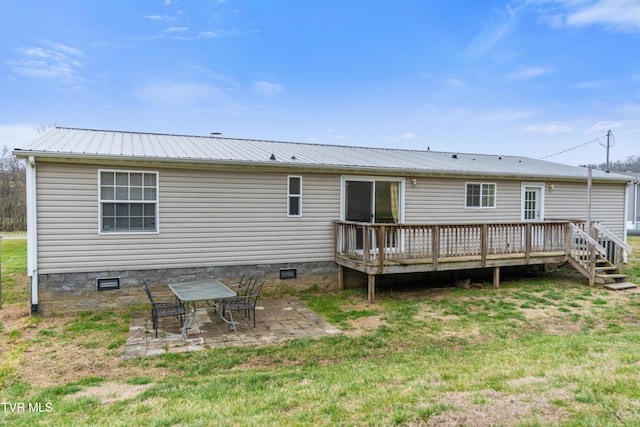 rear view of house featuring crawl space, metal roof, a lawn, and a patio