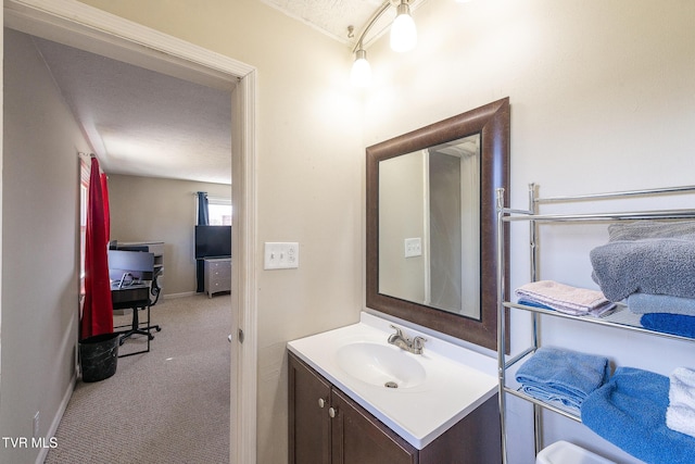 bathroom featuring baseboards, vanity, and a textured ceiling