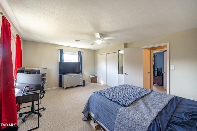 carpeted bedroom featuring a ceiling fan, a closet, a textured ceiling, and baseboards