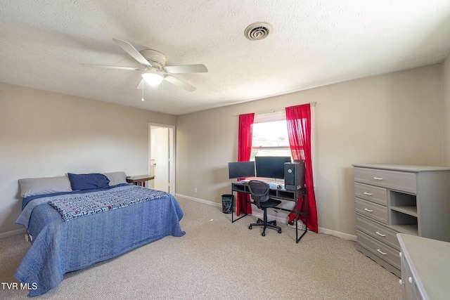 carpeted bedroom with a ceiling fan, visible vents, a textured ceiling, and baseboards