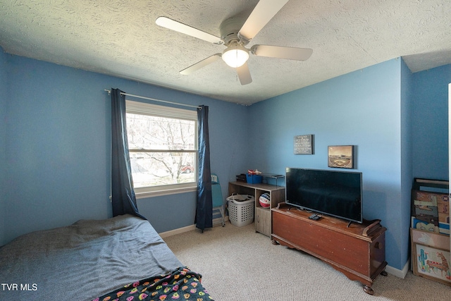 bedroom featuring ceiling fan, a textured ceiling, carpet, and baseboards