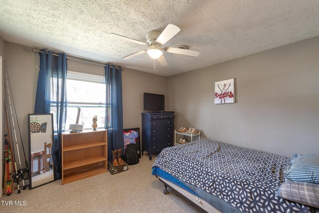 carpeted bedroom featuring ceiling fan and a textured ceiling