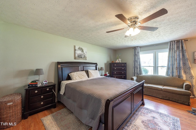 bedroom featuring ceiling fan, a textured ceiling, and wood finished floors