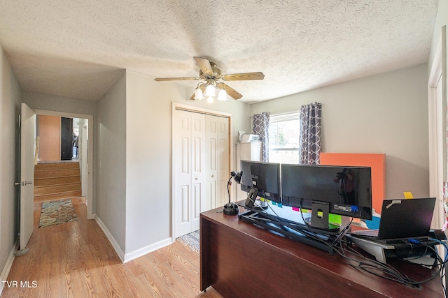 office area featuring a ceiling fan, a textured ceiling, baseboards, and wood finished floors