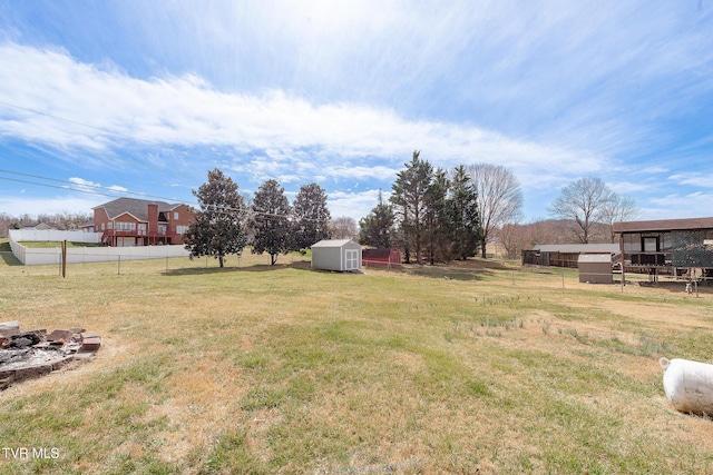 view of yard with fence, an outdoor structure, and a storage shed