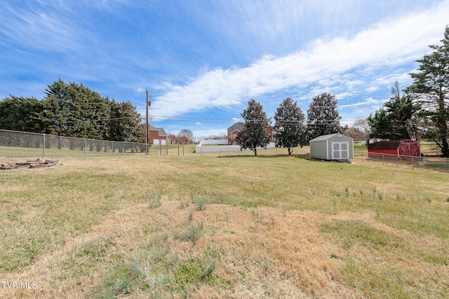 view of yard with a storage shed, an outdoor structure, and fence