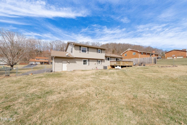 back of house with a fenced backyard, a lawn, and a wooden deck