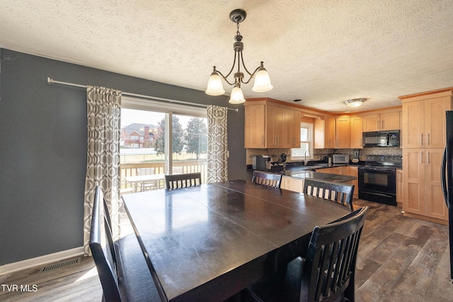 dining space with a chandelier, dark wood finished floors, visible vents, and baseboards