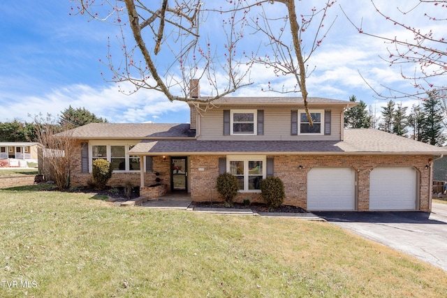 tri-level home with aphalt driveway, brick siding, a chimney, an attached garage, and a front lawn