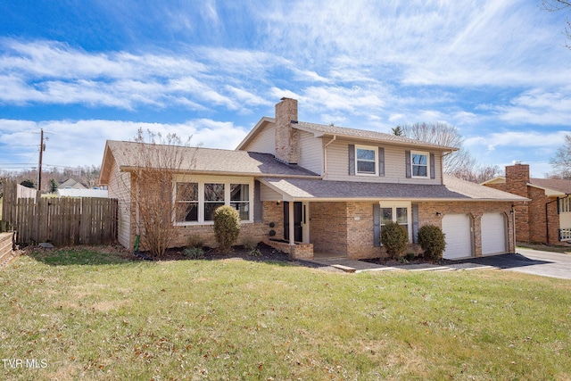 split level home with aphalt driveway, an attached garage, brick siding, fence, and a front yard