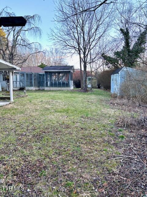 view of yard with a sunroom and an outdoor structure