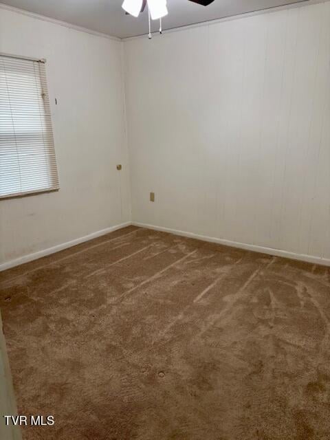 spare room featuring carpet floors, baseboards, and a ceiling fan