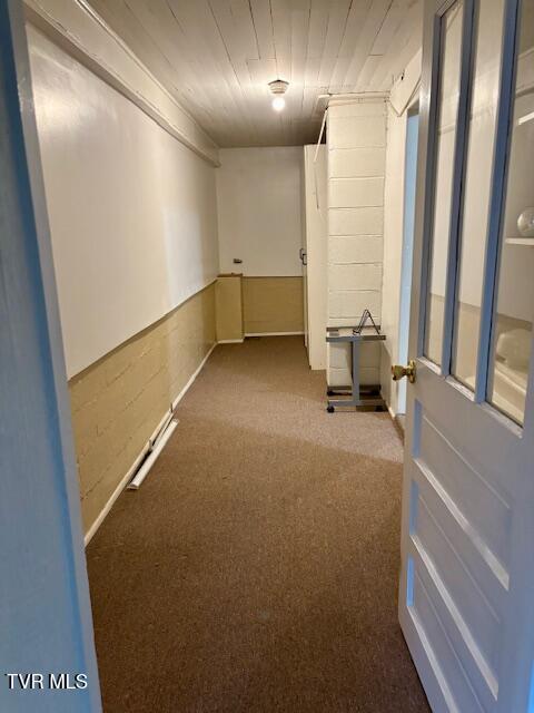 spare room featuring a wainscoted wall and carpet