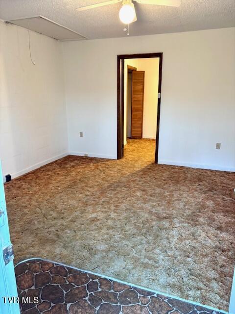 carpeted spare room with ceiling fan and a textured ceiling