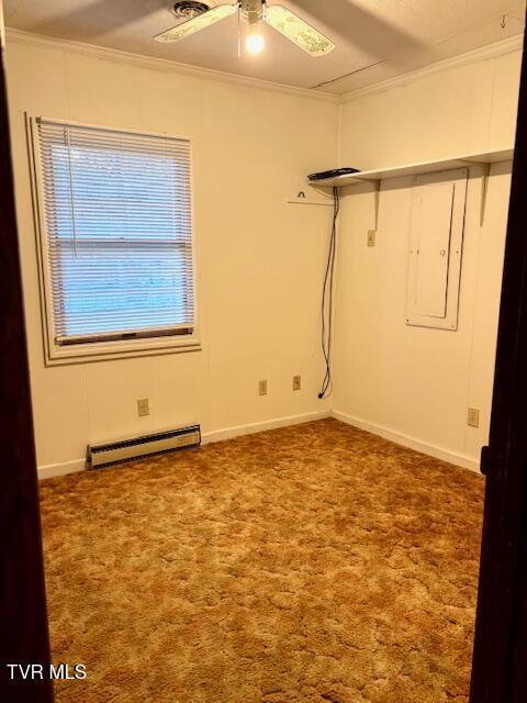 empty room featuring a baseboard radiator, a ceiling fan, baseboards, ornamental molding, and carpet