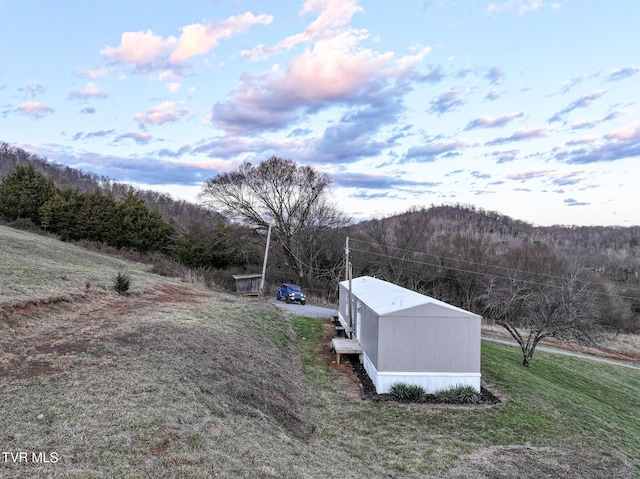 exterior space featuring an outbuilding and a wooded view