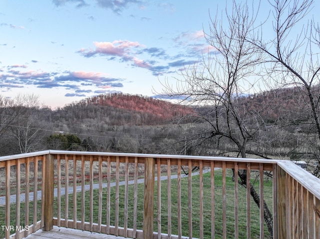 deck featuring a view of trees and a yard