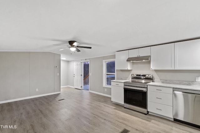 kitchen with under cabinet range hood, light countertops, appliances with stainless steel finishes, light wood-style floors, and white cabinetry