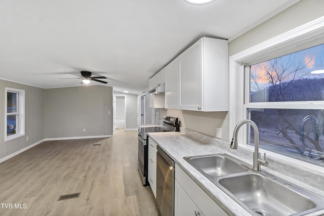 kitchen with visible vents, light countertops, white cabinets, stainless steel appliances, and a sink