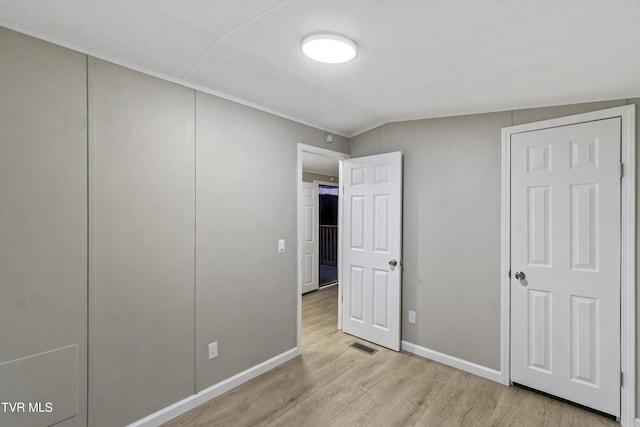 unfurnished bedroom with visible vents, baseboards, a closet, light wood-style floors, and lofted ceiling