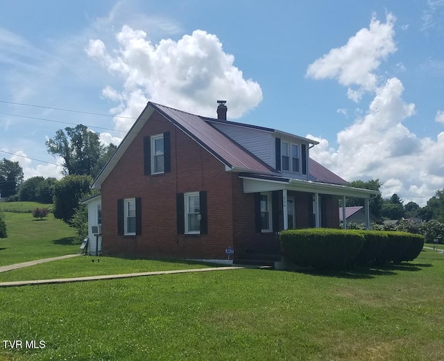 view of property exterior featuring metal roof, a yard, brick siding, and a chimney