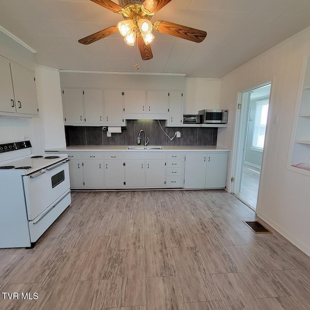 204 Highland Ave, Glade Spring, VA 24340 - kitchen with electric range, stainless steel microwave, a ceiling fan, white cabinetry, and decorative backsplash