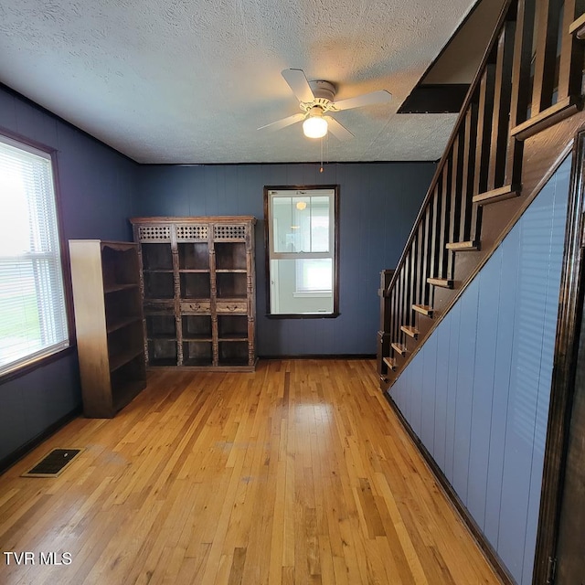 204 Highland Ave, Glade Spring, VA 24340 - unfurnished living room with healthy amount of natural light, hardwood / wood-style flooring, a textured ceiling, a ceiling fan, and stairway