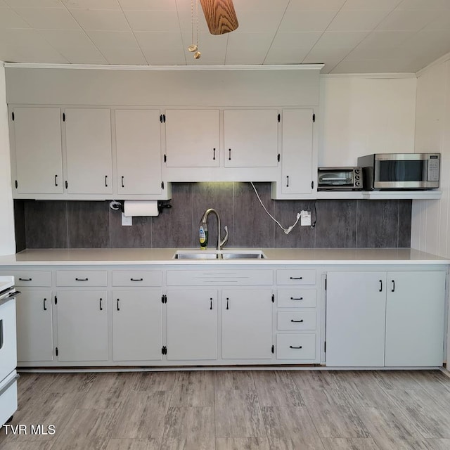 204 Highland Ave, Glade Spring, VA 24340 - kitchen featuring stainless steel microwave, light countertops, white cabinets, and backsplash