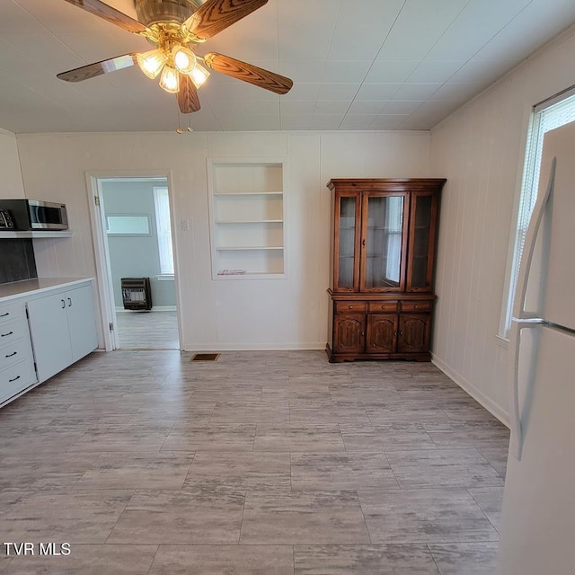 204 Highland Ave, Glade Spring, VA 24340 - kitchen with built in shelves, stainless steel microwave, ceiling fan, freestanding refrigerator, and heating unit