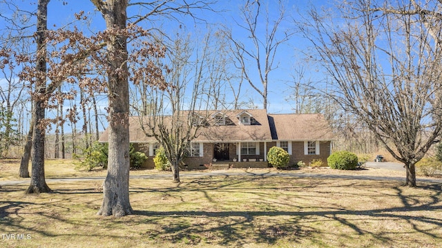 cape cod house with crawl space, brick siding, and a front yard