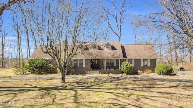 cape cod-style house featuring a front yard, brick siding, and crawl space