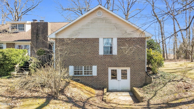 view of side of home with brick siding and a chimney