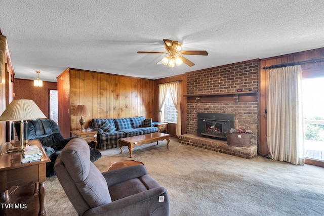 carpeted living room with wooden walls, a textured ceiling, and a ceiling fan