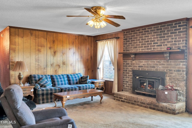 living area featuring a ceiling fan, a textured ceiling, wood walls, and carpet flooring