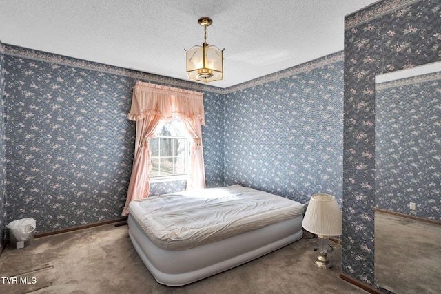 bedroom with a textured ceiling, wallpapered walls, baseboards, and carpet floors