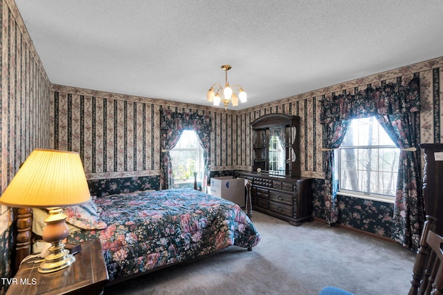 carpeted bedroom featuring baseboards, a textured ceiling, a chandelier, and wallpapered walls