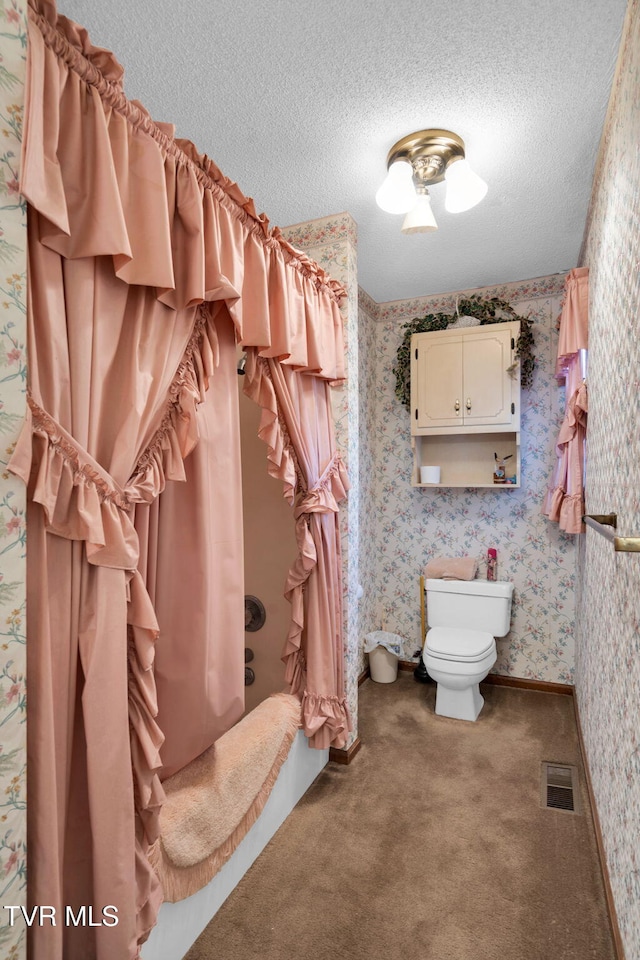 full bathroom featuring visible vents, toilet, a textured ceiling, and wallpapered walls