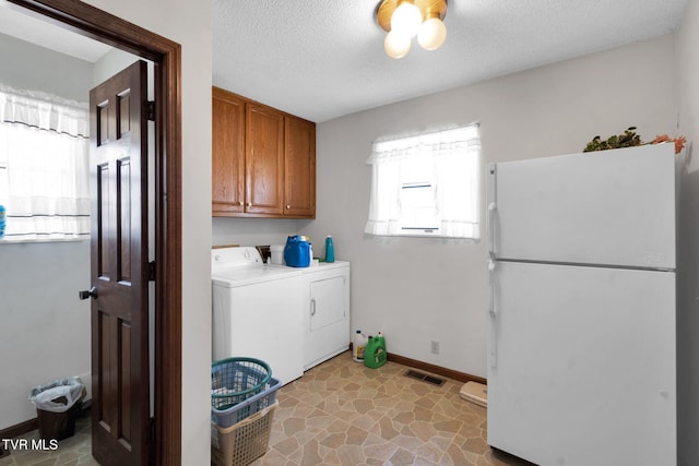 washroom with visible vents, a textured ceiling, cabinet space, baseboards, and washing machine and clothes dryer