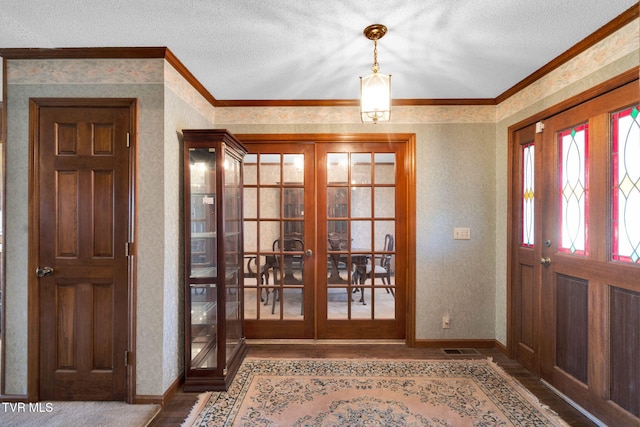 foyer with wallpapered walls, wood finished floors, and french doors