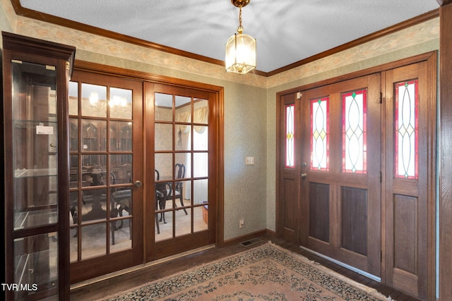 entrance foyer featuring wallpapered walls, crown molding, wood finished floors, and french doors