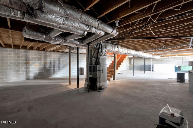 unfinished basement with heating unit and stairs