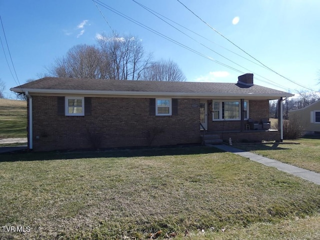 single story home with brick siding, a chimney, a front lawn, and roof with shingles