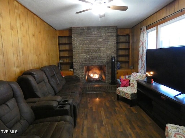 living area with built in features, a brick fireplace, wood walls, and wood finished floors