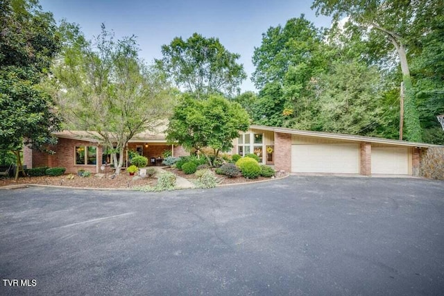 view of front facade with brick siding, driveway, and a garage