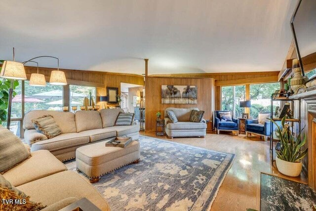 living room with plenty of natural light, wood walls, and wood finished floors