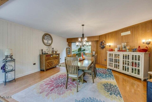 dining room featuring baseboards, an inviting chandelier, and wood finished floors