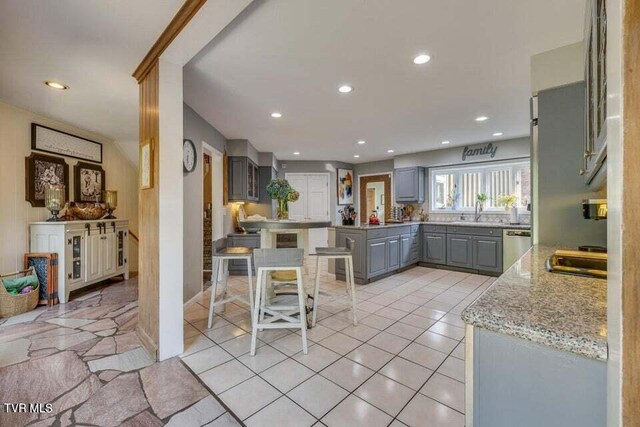 kitchen with stainless steel dishwasher, light tile patterned floors, recessed lighting, and gray cabinetry