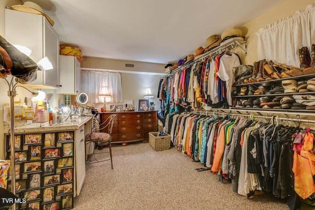 walk in closet with visible vents and light carpet